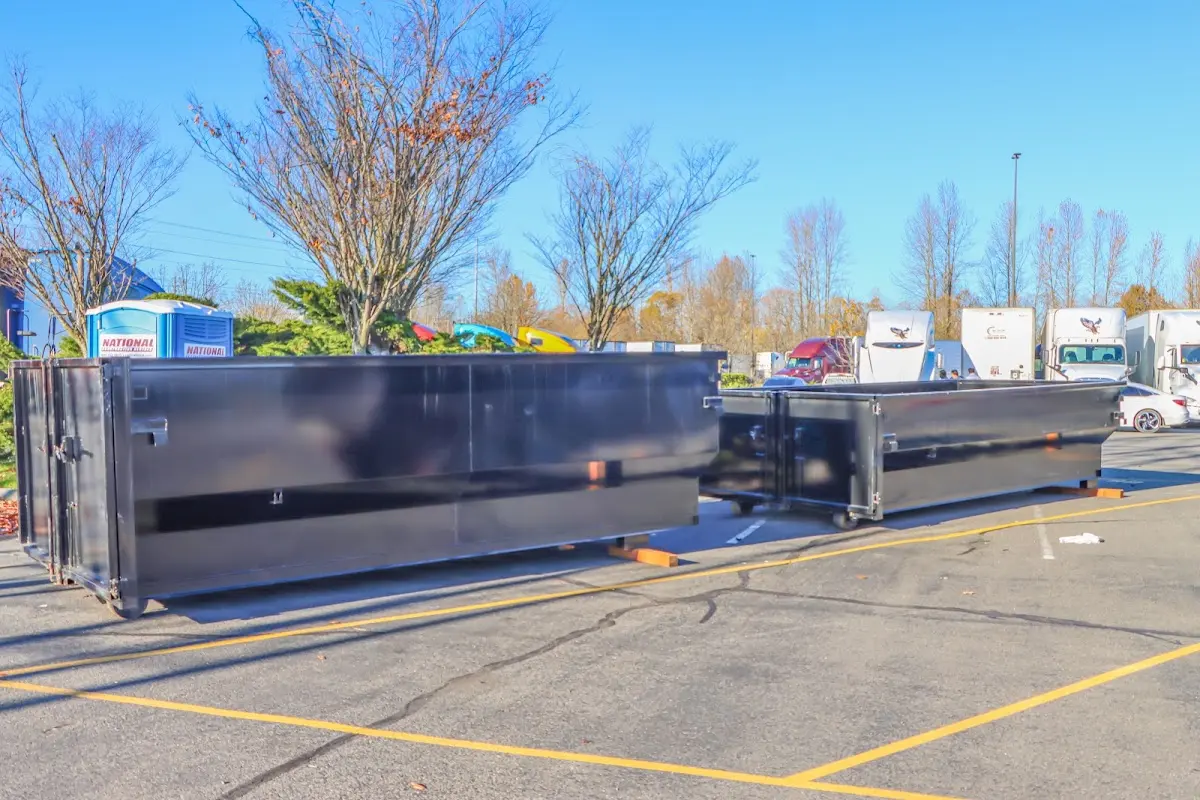 Professional dumpster rental service with roll-off container on residential driveway in Roanoke